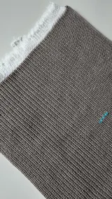 Machine-knitted swatch in grey beige melange yarn